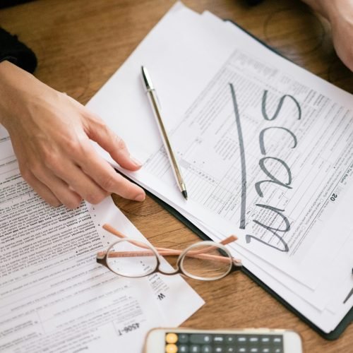 A close look at tax forms marked with scam, highlighting financial fraud risks.